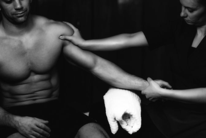 A sports message therapist providing message to a sports man